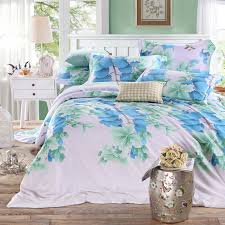 ملاءة سرير بيضاء مطرزة ببقات من الزهور الملونة