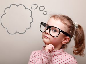 cute thinking kid girl in glasses with empty bubble looking